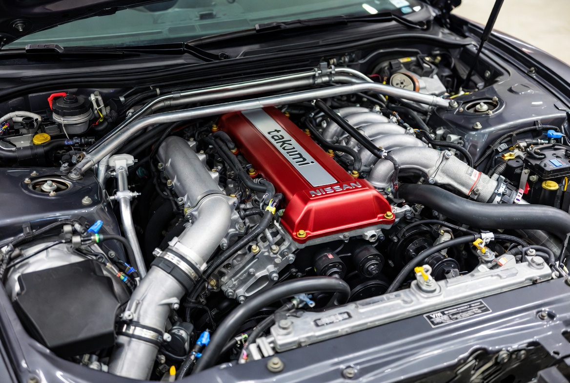 R35 GT-R VR38DETT twin-turbocharged engine bay detail showing hand-assembled craftsmanship